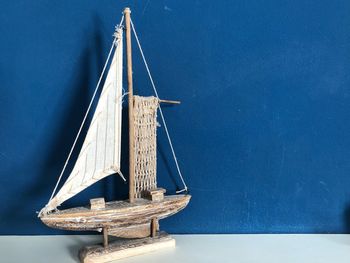 Small sailboat on table against wall