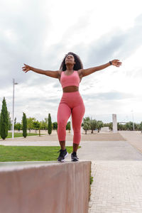 Full length of woman walking on retaining wall at park