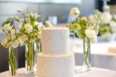 Close-up of wedding cake on table with flowers