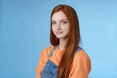 Redhead woman against blue background