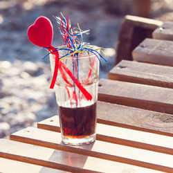 Glass of alcoholic cocktail standing in the sand on a tropical beach at sunset in the evening