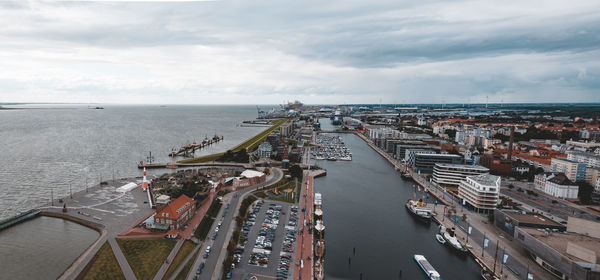 High angle view of city by sea against sky