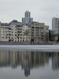 Reflection of buildings in lake against sky