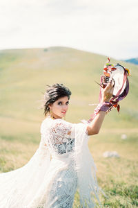 Portrait of young woman standing on field