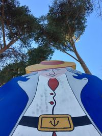 Close-up of road sign against blue sky