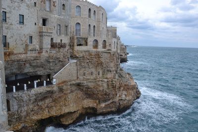 View of built structure by sea
