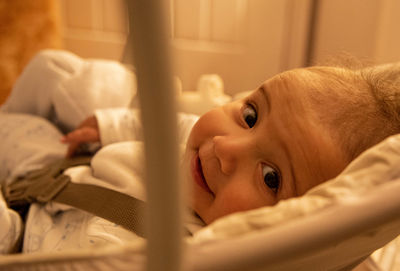 Portrait of cute baby lying on bed at home