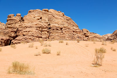 Rock formations in desert against clear blue sky