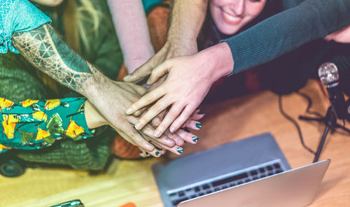 Cropped image of colleagues stacking hands