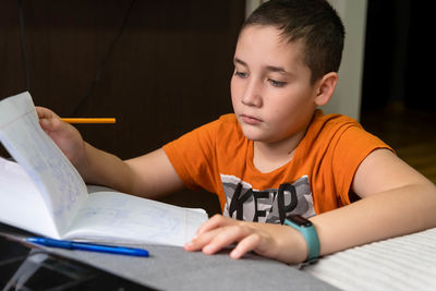 Boy with book studying at home