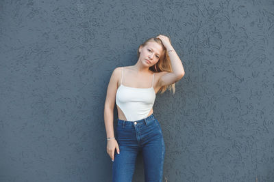 Portrait of woman standing against wall