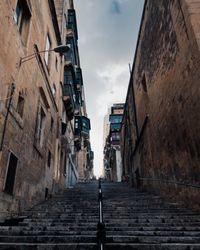 Low angle view of steps amidst buildings in city