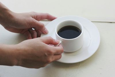 Close-up of hand holding coffee cup