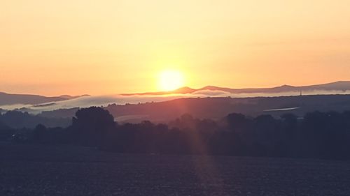 Scenic view of silhouette mountains against sky during sunset