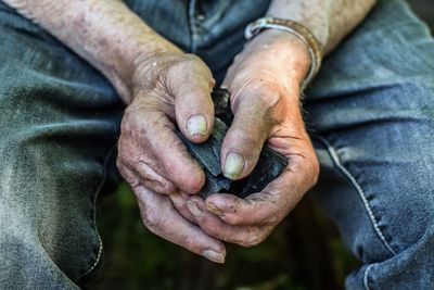 Midsection of man holding charcoal