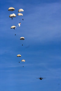 Low angle view of person paragliding against clear blue sky