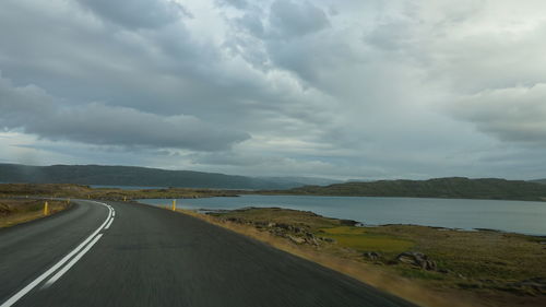 Empty road against cloudy sky