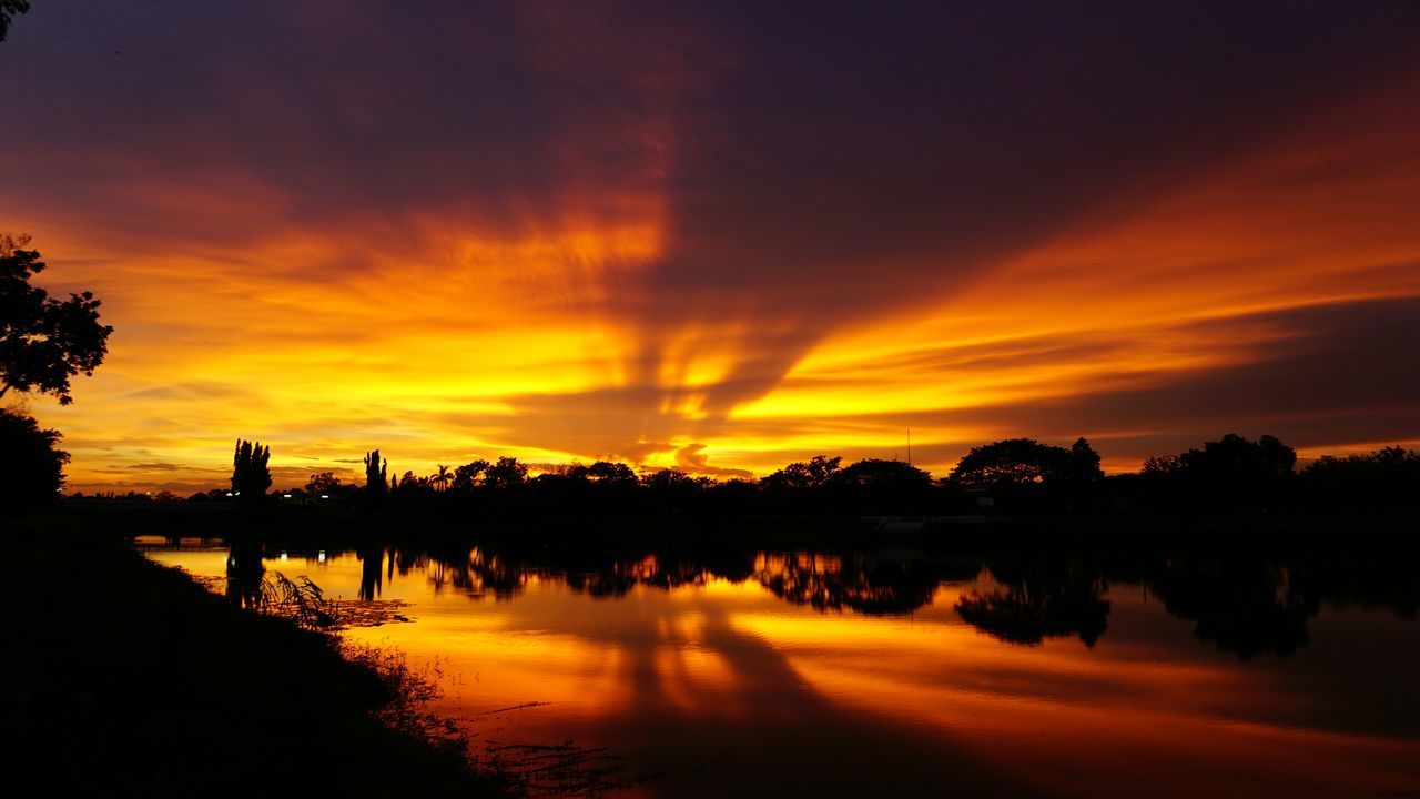 sunset, silhouette, water, reflection, orange color, sky, scenics, tranquil scene, beauty in nature, tranquility, lake, idyllic, cloud - sky, nature, waterfront, tree, river, dramatic sky, cloud, moody sky