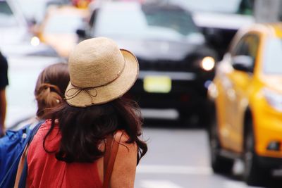 Rear view of woman with umbrella on street in city