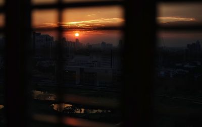 Silhouette cityscape against sky during sunset