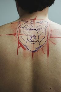 Rear view of shirtless man standing on paper