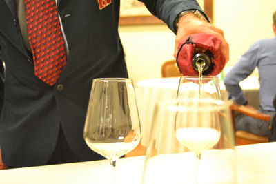 Man pouring wine in glass on table