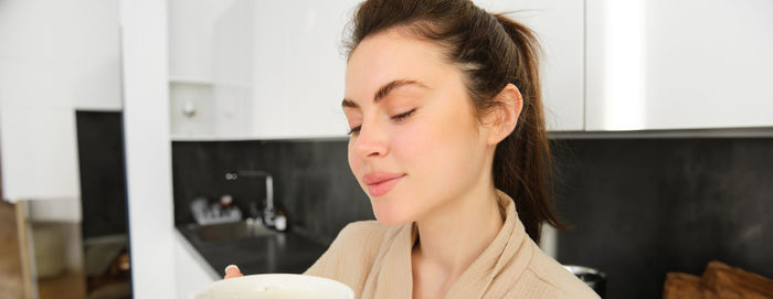 Young woman drinking coffee at home