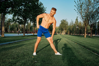 Full length of man exercising on field