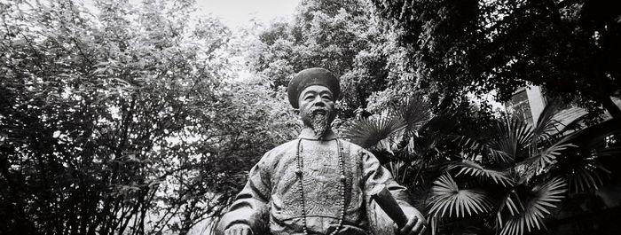 Low angle view of statue against trees