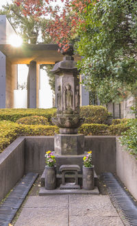 Statue by fountain against building