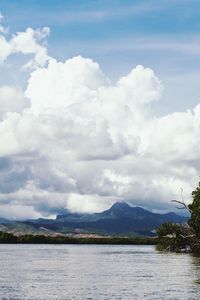 Scenic view of lake and mountains against cloudy sky