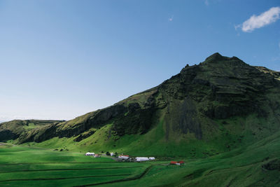 Scenic view of houses in green, lush, rolling mountains