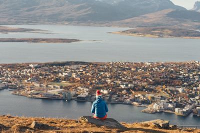 Man standing by sea against cityscape