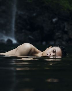 Close-up of young woman swimming in water