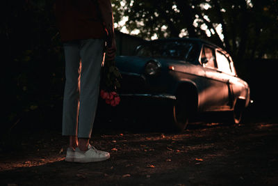 Low section of woman standing on car