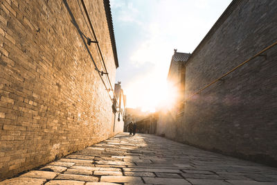 Footpath amidst buildings against sky