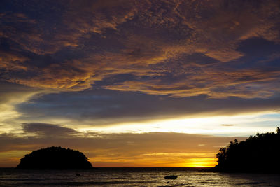 Scenic view of sea against dramatic sky during sunset