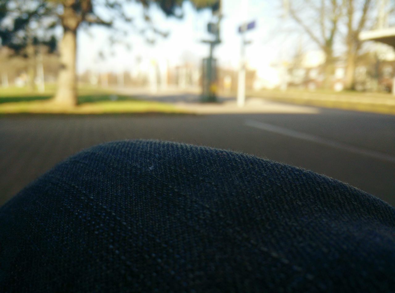 focus on foreground, tree, street, road, selective focus, surface level, close-up, transportation, day, outdoors, asphalt, sunlight, car, the way forward, no people, nature, incidental people, part of, empty, absence