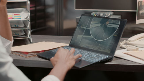 Midsection of woman using laptop on table