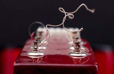 Broken strings of guitar against black background