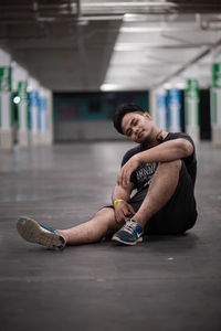 Portrait of young man sitting in parking garage