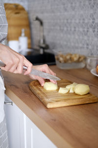 Cropped hand preparing food on cutting board
