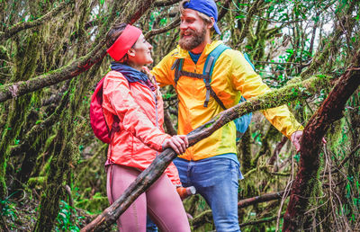 Couple standing by trees in forest