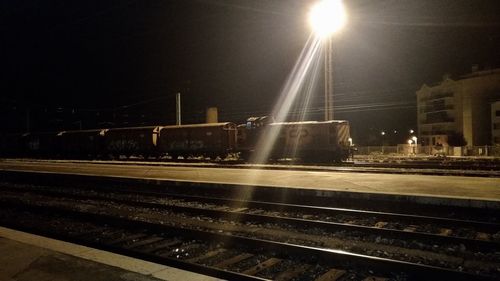 Illuminated railroad station platform at night