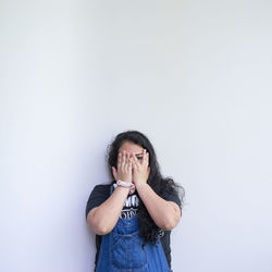 Young woman standing against white background