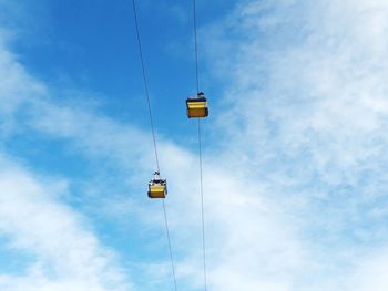 Low angle view of overhead cable car against sky