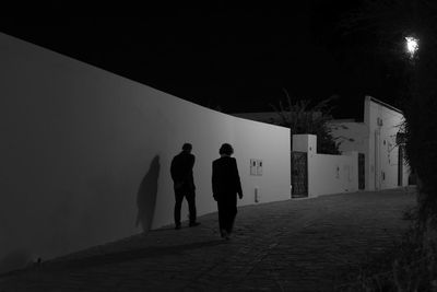 Low angle view of silhouette people walking in tunnel