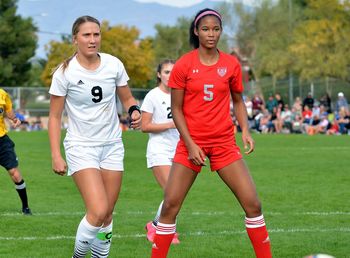 Full length of man and woman in soccer field