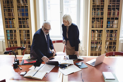 Senior lawyers using laptop at table in library