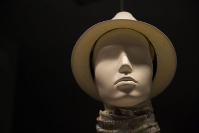 Close-up of female mannequin against black background